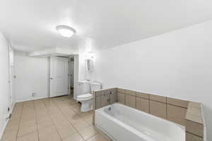 Bathroom featuring a bath, light tile patterned flooring, and vanity