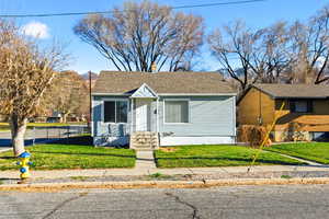 Bungalow-style home featuring a chimney, roof with shingles, and entry steps