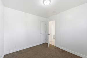 Unfurnished bedroom featuring carpet and baseboards