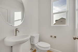 Bathroom with toilet and wood finished floors