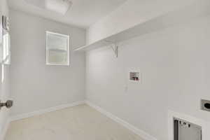 Laundry area with light marble finish floors, washer hookup, and electric dryer hookup