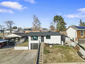 View of front of home featuring an attached garage, driveway, a residential view, and brick siding