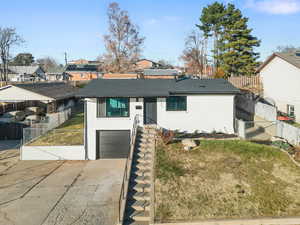 View of front of home featuring an attached garage, driveway, a residential view, and brick siding