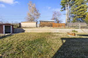 Fenced backyard featuring an outbuilding