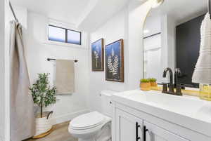 Full bathroom with vanity, a shower with curtain, and light wood finished floors