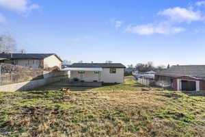 Rear view of property featuring a fenced backyard and a patio