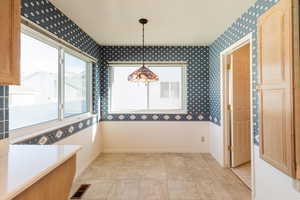 Unfurnished dining area featuring plenty of natural light and wallpapered walls