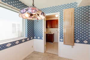 Bathroom featuring wallpapered walls and a chandelier