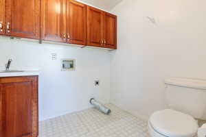 Washroom featuring light flooring, hookup for a washing machine, and electric dryer hookup