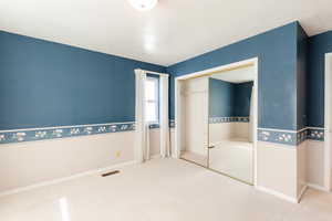 Unfurnished bedroom with carpet flooring, a textured ceiling, and a closet