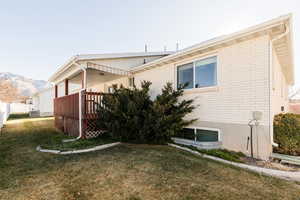 View of property exterior featuring brick siding and a wooden deck