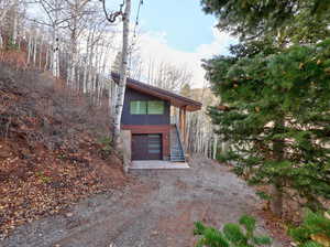 Contemporary house with driveway, stairs, and a garage