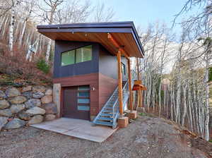 View of front of home featuring stairway, driveway, and an attached garage