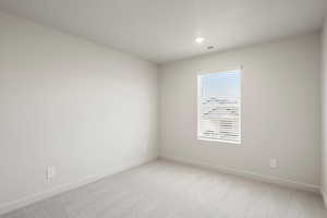 Empty room with baseboards and light colored carpet