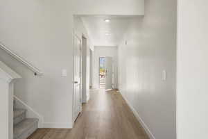Hall featuring stairs and light wood finished floors