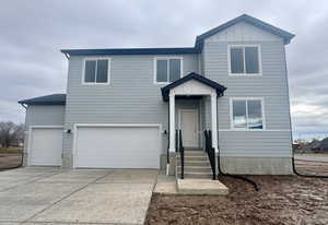 View of front of house featuring driveway, a garage, and board and batten siding
