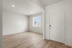 Foyer with light wood-type flooring and recessed lighting