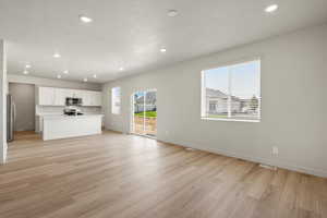 Unfurnished living room featuring recessed lighting, light wood-type flooring, and a textured ceiling
