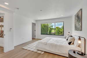 Bedroom featuring light wood-style floors, recessed lighting, and a textured ceiling