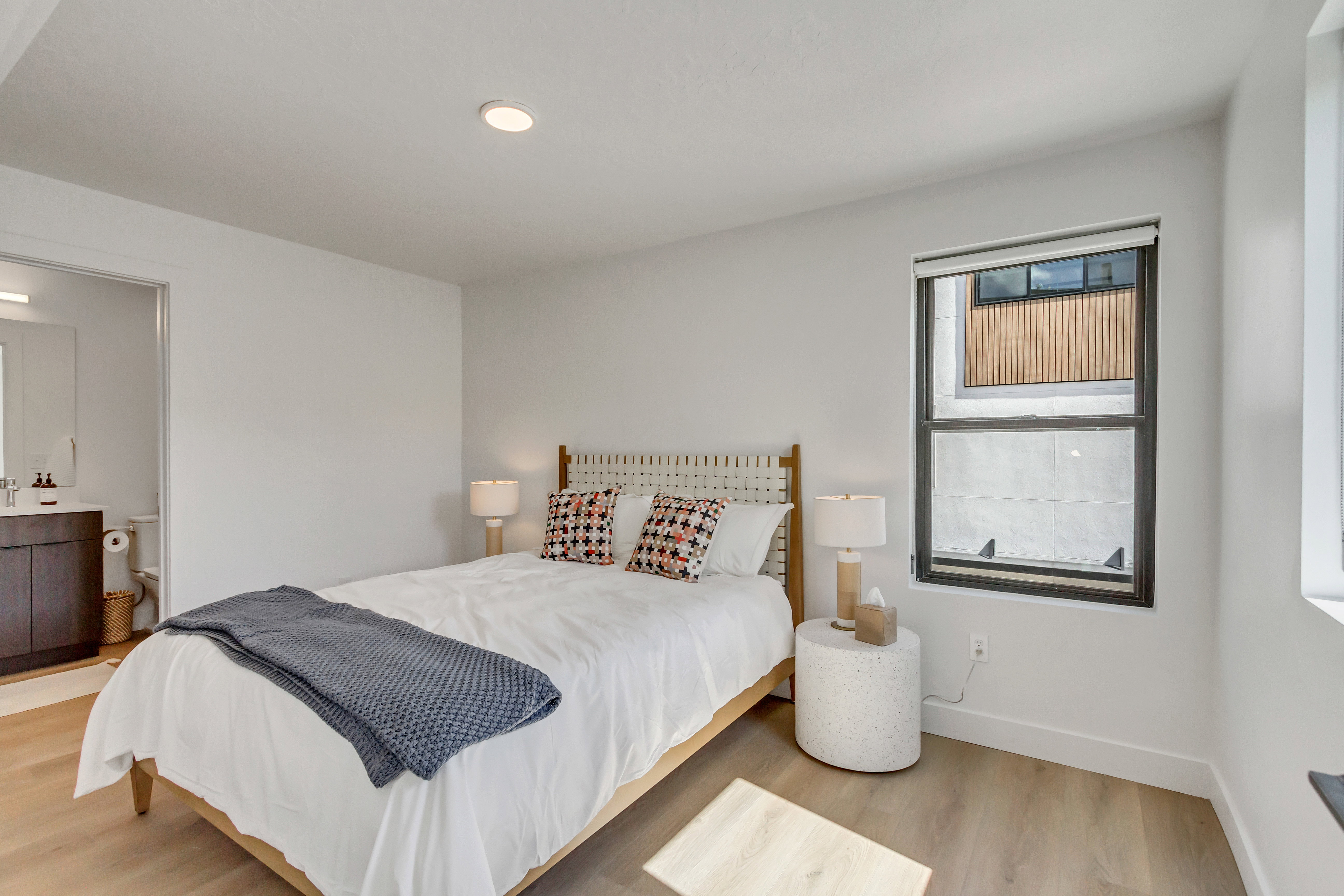 Bedroom featuring light wood-style flooring, ensuite bathroom, and recessed lighting