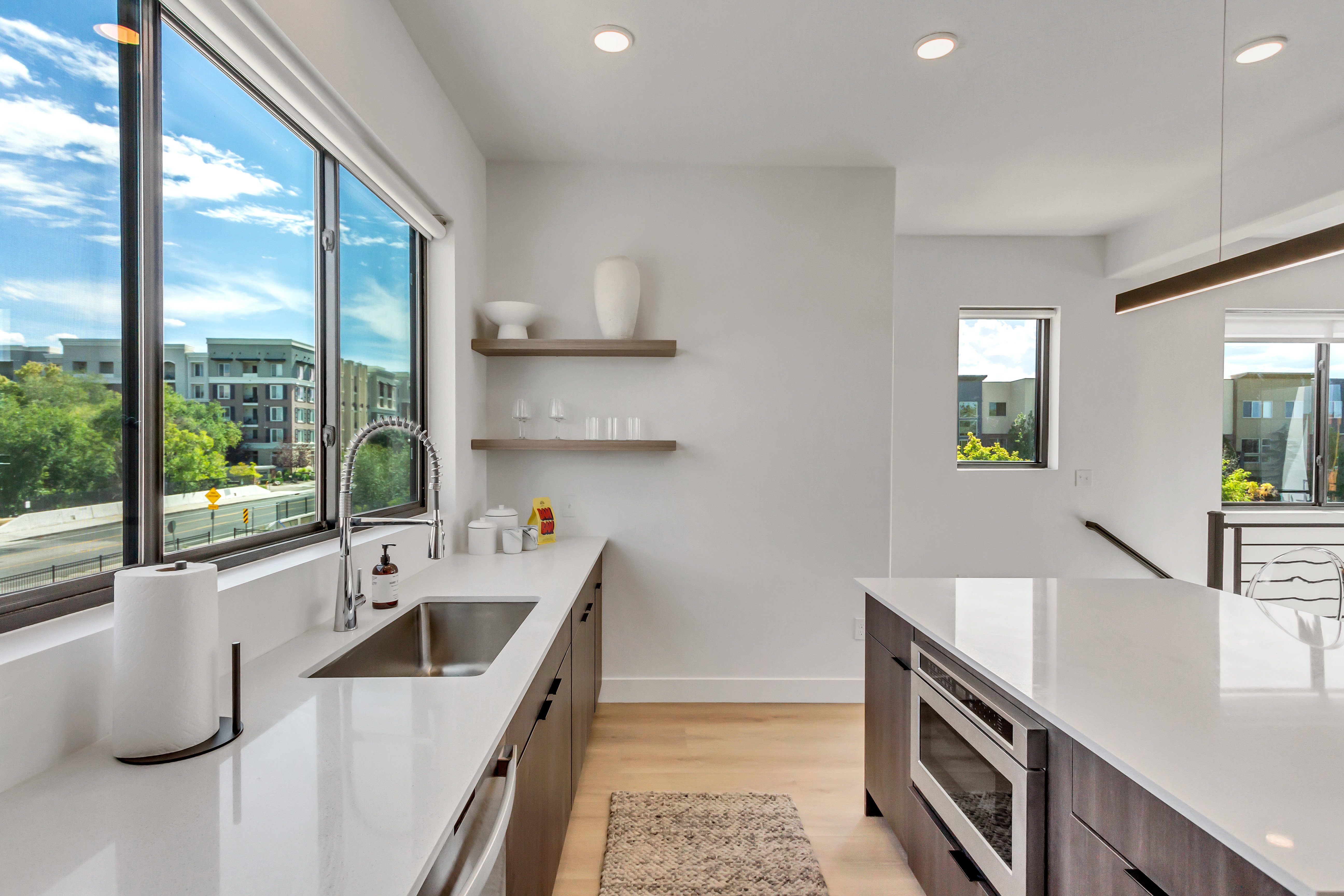Kitchen featuring open shelves, recessed lighting, light wood finished floors, light stone countertops, and stainless steel appliances