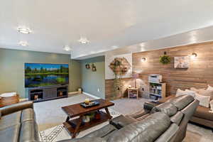 Carpeted living area featuring wood walls and an accent wall