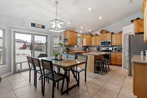 Dining area featuring lofted ceiling, recessed lighting, and light tile patterned flooring