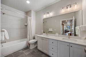 Full bathroom with double vanity and shower / tub combo with curtain
