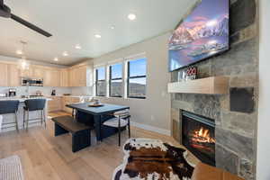 Dining area featuring light wood-style flooring, recessed lighting, and a large fireplace
