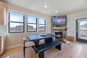 Dining room with a stone fireplace, plenty of natural light, light wood finished floors, and recessed lighting