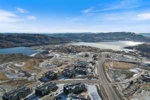 Snowy aerial view featuring a water and mountain view