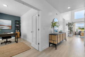 Hall featuring a desk, a textured ceiling, light wood-type flooring, and recessed lighting