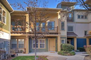 View of front of home featuring a balcony and stucco siding