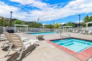Community pool with a patio area and a community hot tub
