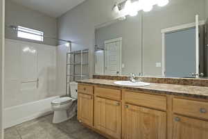 Bathroom with vanity, shower / bathtub combination, and light tile patterned floors