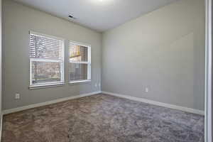 Carpeted empty room featuring baseboards