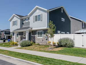 View of front of home featuring stone siding and covered porch