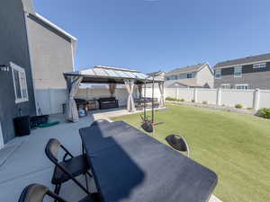 Fenced backyard featuring a gazebo, a patio area, an outdoor hangout area, outdoor dining area, and a residential view