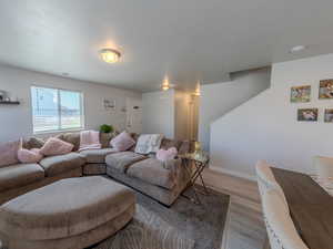 Living room featuring wood finished floors and stairway