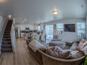 Living room featuring stairs, recessed lighting, and light wood-type flooring