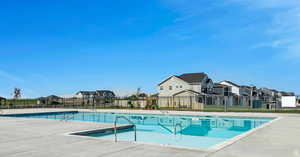 Community pool with a residential view and a patio area