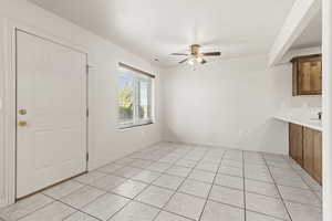 Unfurnished dining area featuring ceiling fan and light tile patterned floors