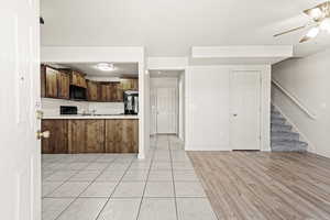 Kitchen featuring light countertops, a peninsula, light wood finished floors, ceiling fan, and open floor plan