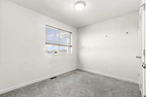 Empty room with carpet flooring and baseboards