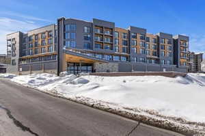 Snow covered property with a view of apartment building / complex