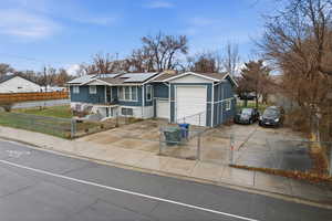 Ranch-style house featuring a gate, a fenced front yard, driveway, and solar panels