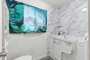 Full bath featuring a garden tub and a textured ceiling