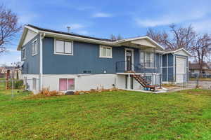 Back of property with a gate, stairway, and solar panels