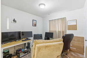 Carpeted office featuring a textured ceiling