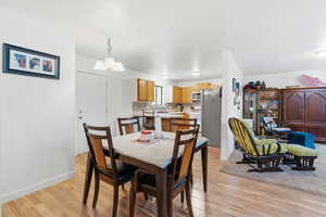 Dining area featuring light wood finished floors and a chandelier